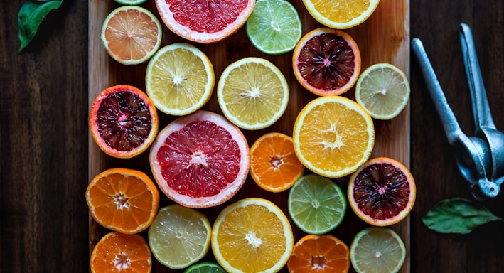 assorted sliced citrus fruits on brown wooden chopping board