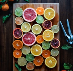 assorted sliced citrus fruits on brown wooden chopping board