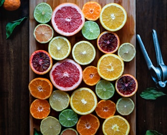 assorted sliced citrus fruits on brown wooden chopping board