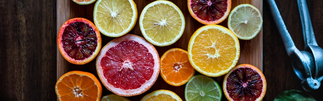 assorted sliced citrus fruits on brown wooden chopping board