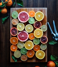 assorted sliced citrus fruits on brown wooden chopping board