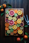 assorted sliced citrus fruits on brown wooden chopping board