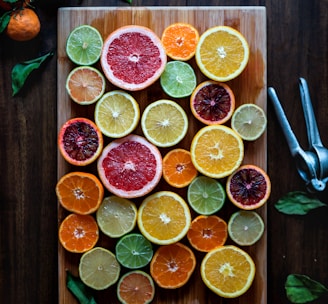 assorted sliced citrus fruits on brown wooden chopping board