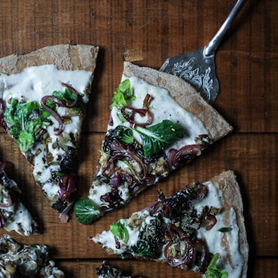 sliced pizza with leafy vegetable toppings