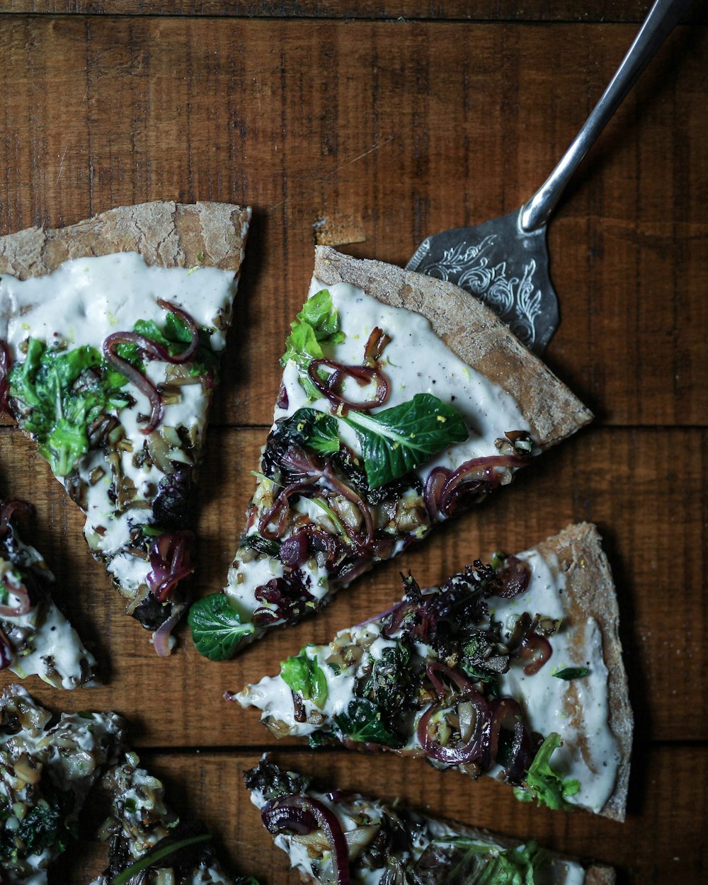 sliced pizza with leafy vegetable toppings