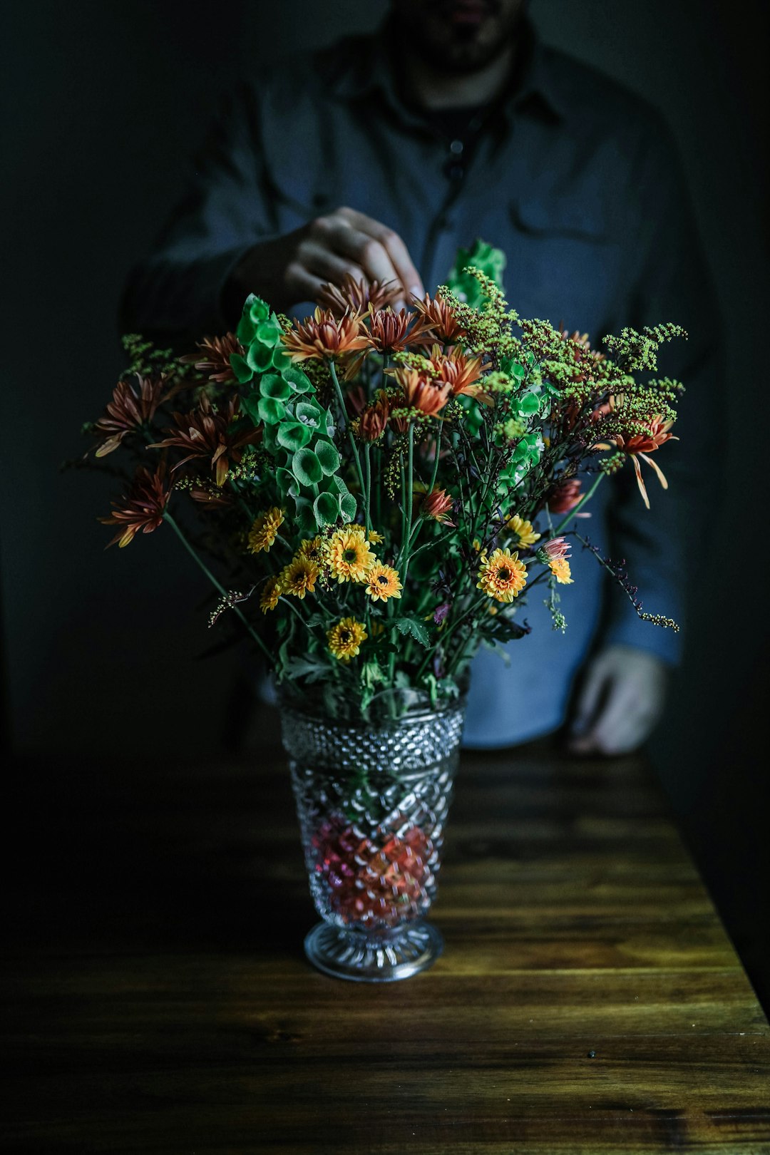 person touching vase of flowers