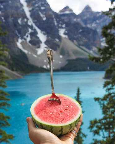 person holding slice of watermelon with fork