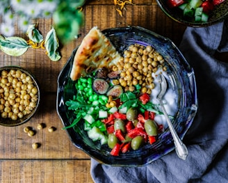 silver spoon on black ceramic bowl with vegetables