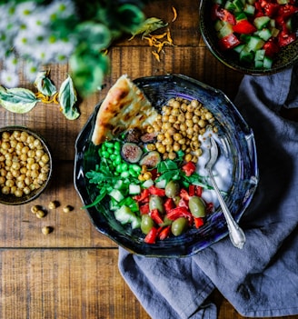 silver spoon on black ceramic bowl with vegetables