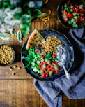 silver spoon on black ceramic bowl with vegetables
