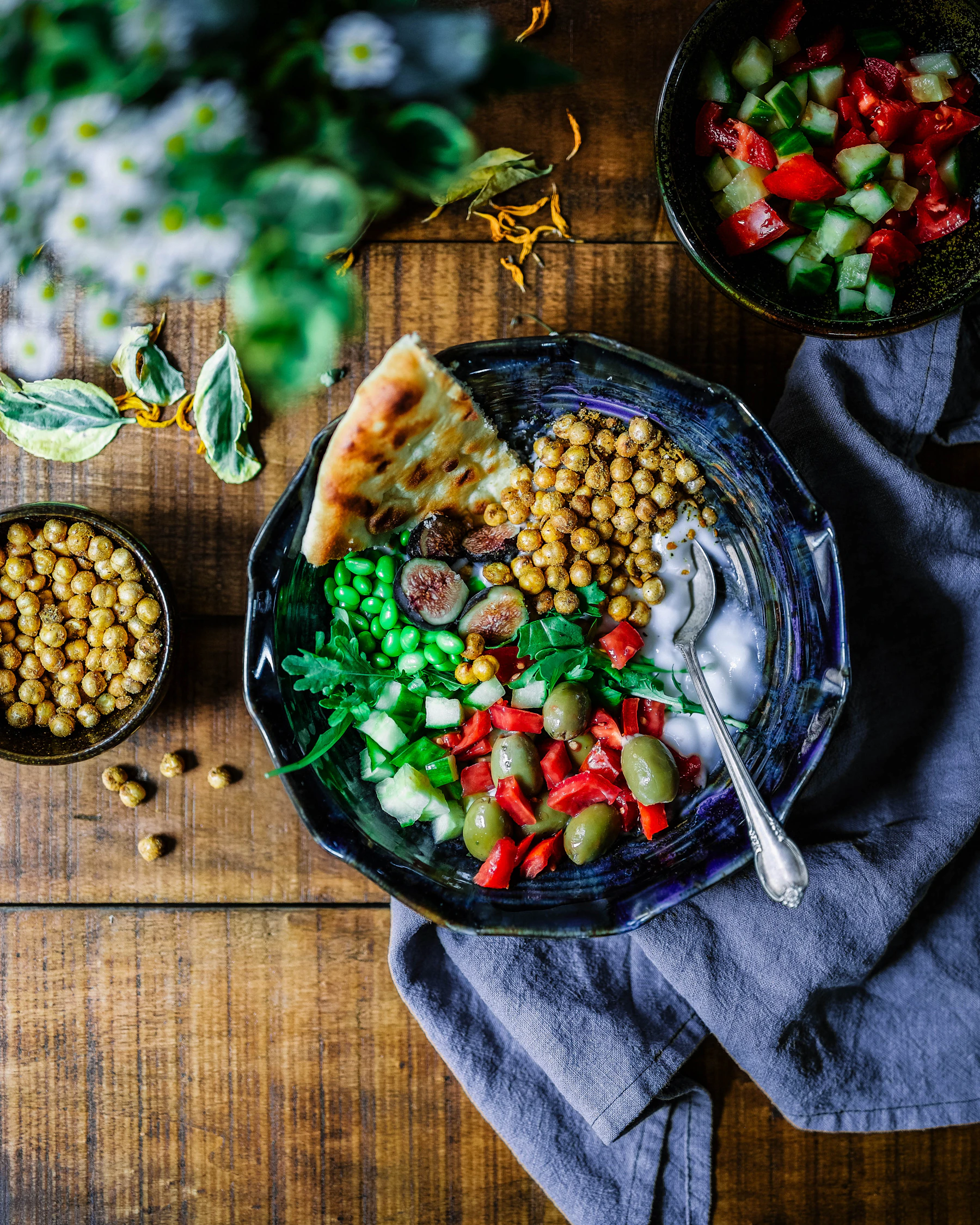 Shared food and fresh ingredients arranged on a warm table
