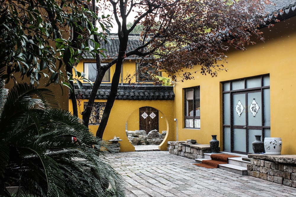 photo of yellow and gray house near trees