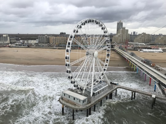 Ferris wheel on structure near beach in Das Pier Netherlands