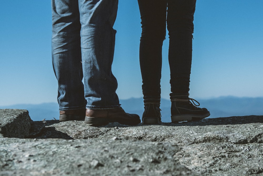 duas pessoas vestindo calça jeans em pé uma ao lado da outra