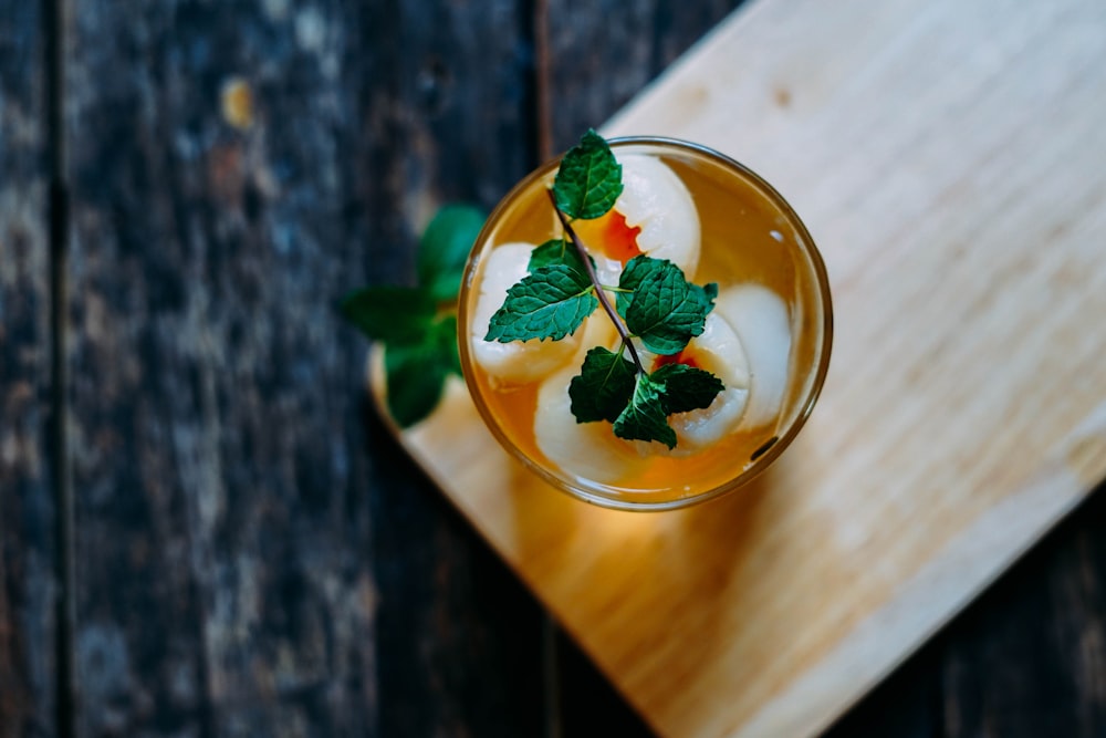 top-view photography of full-filled cup with green leaves topping