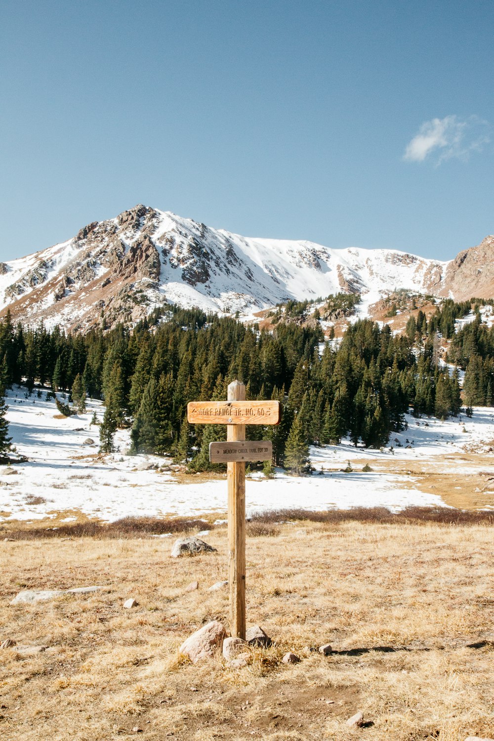 Pie de señalización de madera en el suelo y vista de la montaña nevada