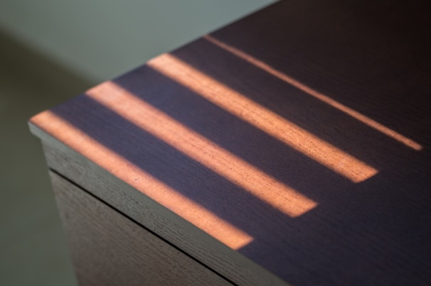 Soft morning light casting shadows over a wooden table with ancient grains and herbs.