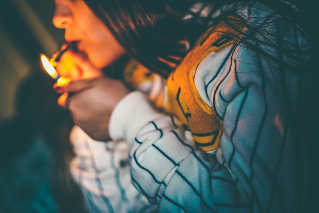 woman in white sweater lighting a joint