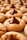 A close-up view of peanut butter cookies topped with a chocolate candy. The cookies have a soft, golden texture with a sugary coating, and each one is centered with a large, dark chocolate drop.