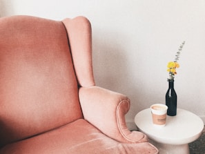 Plush armchair next to a small coffee table with a book and cup.