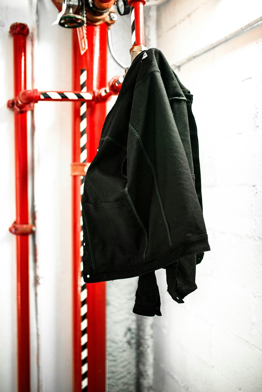 black coat hanging on red coat raack