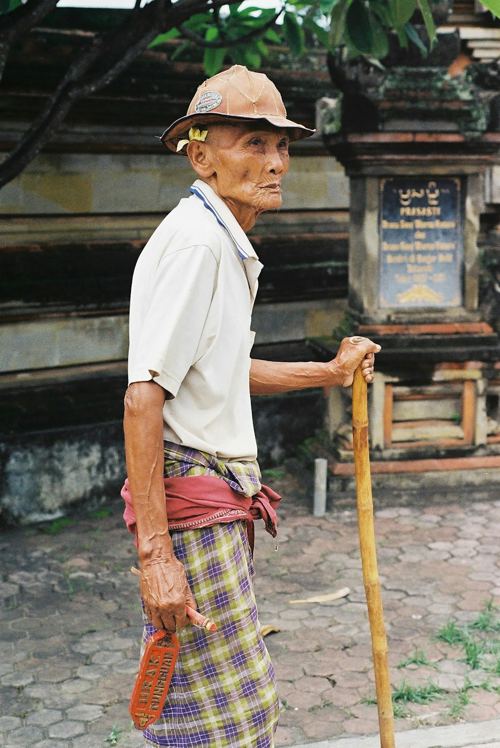 hombre sosteniendo un bastón de madera marrón