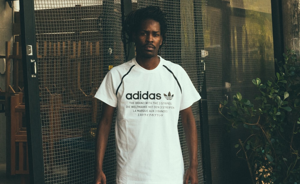 man wearing white and black adidas crew-neck t-shirt