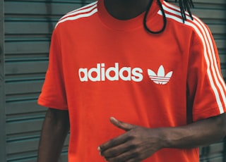 man wearing red and white adidas crew-neck T-shirt