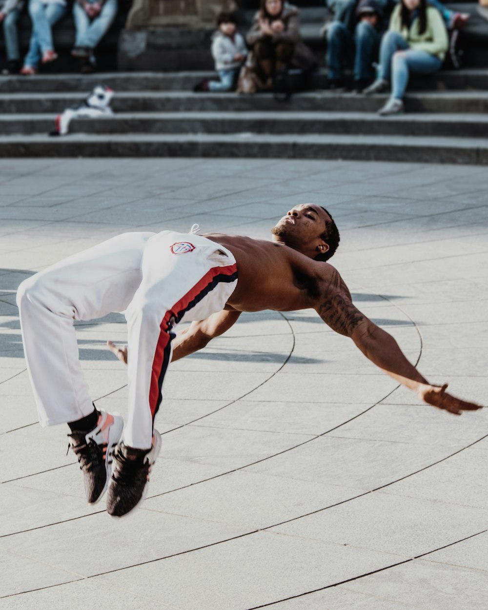 man doing acrobat trick in front of people