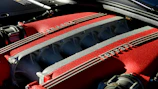 Polished Ferrari engine components neatly arranged on a workbench.