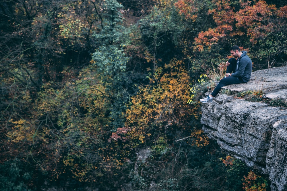 man sitting on cliff