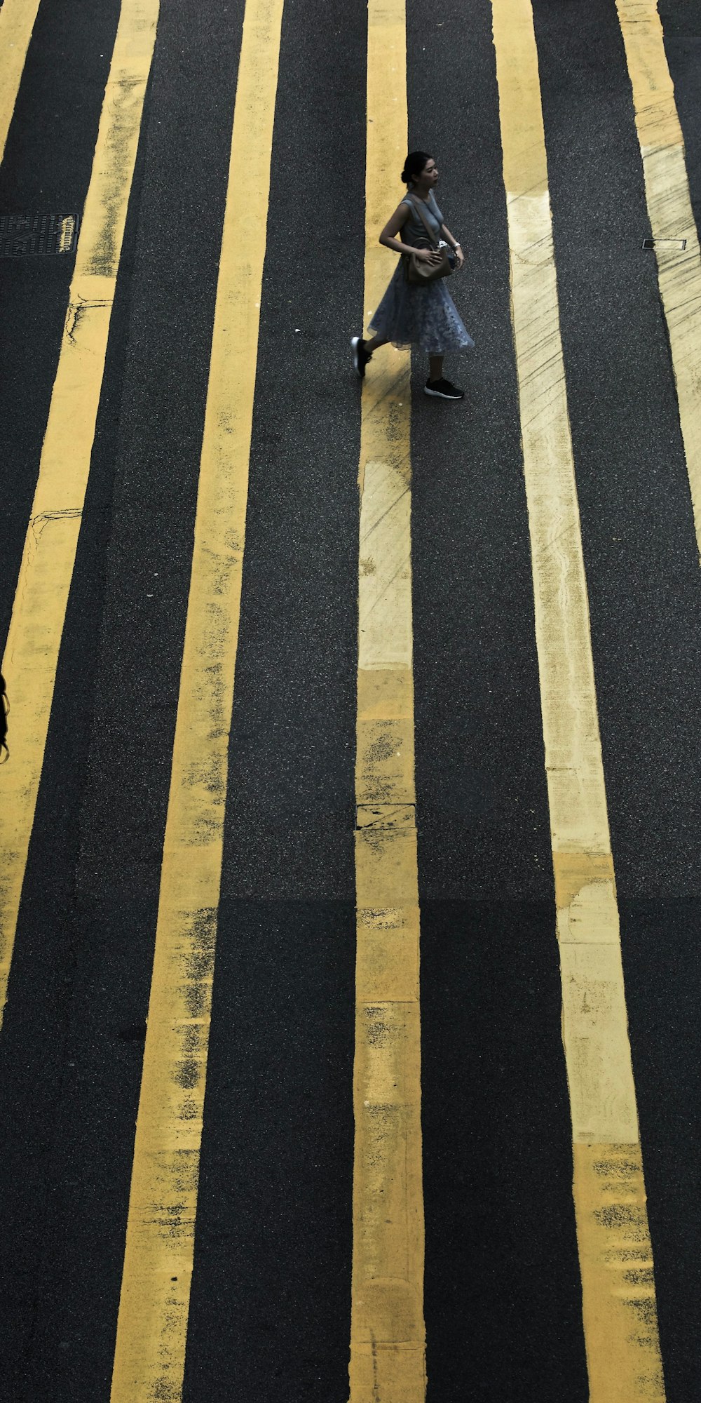 woman crossing pedestrian during daytime