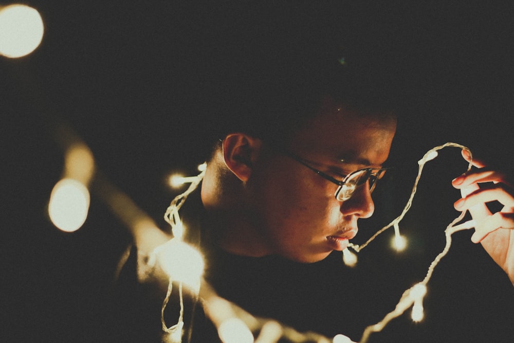 man holding string lights