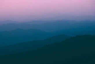 A serene landscape painting featuring pastel skies over rolling hills.