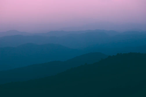 A serene landscape painting featuring pastel skies over rolling hills.
