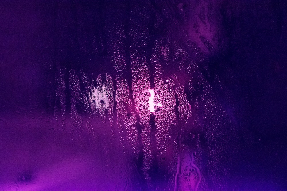 um close up de uma janela com uma luz roxa