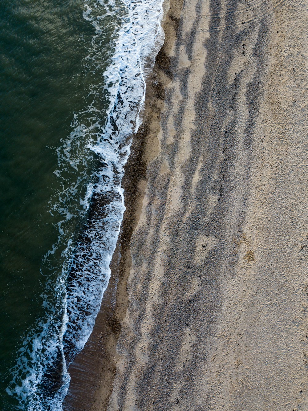 gray sand on seashore at daytime