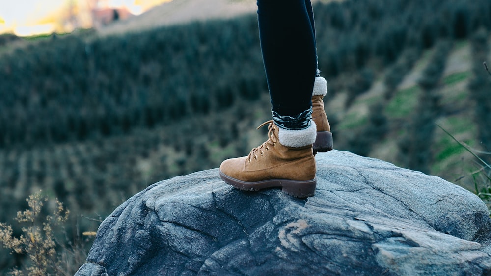 selective focus photography of person standing on rock