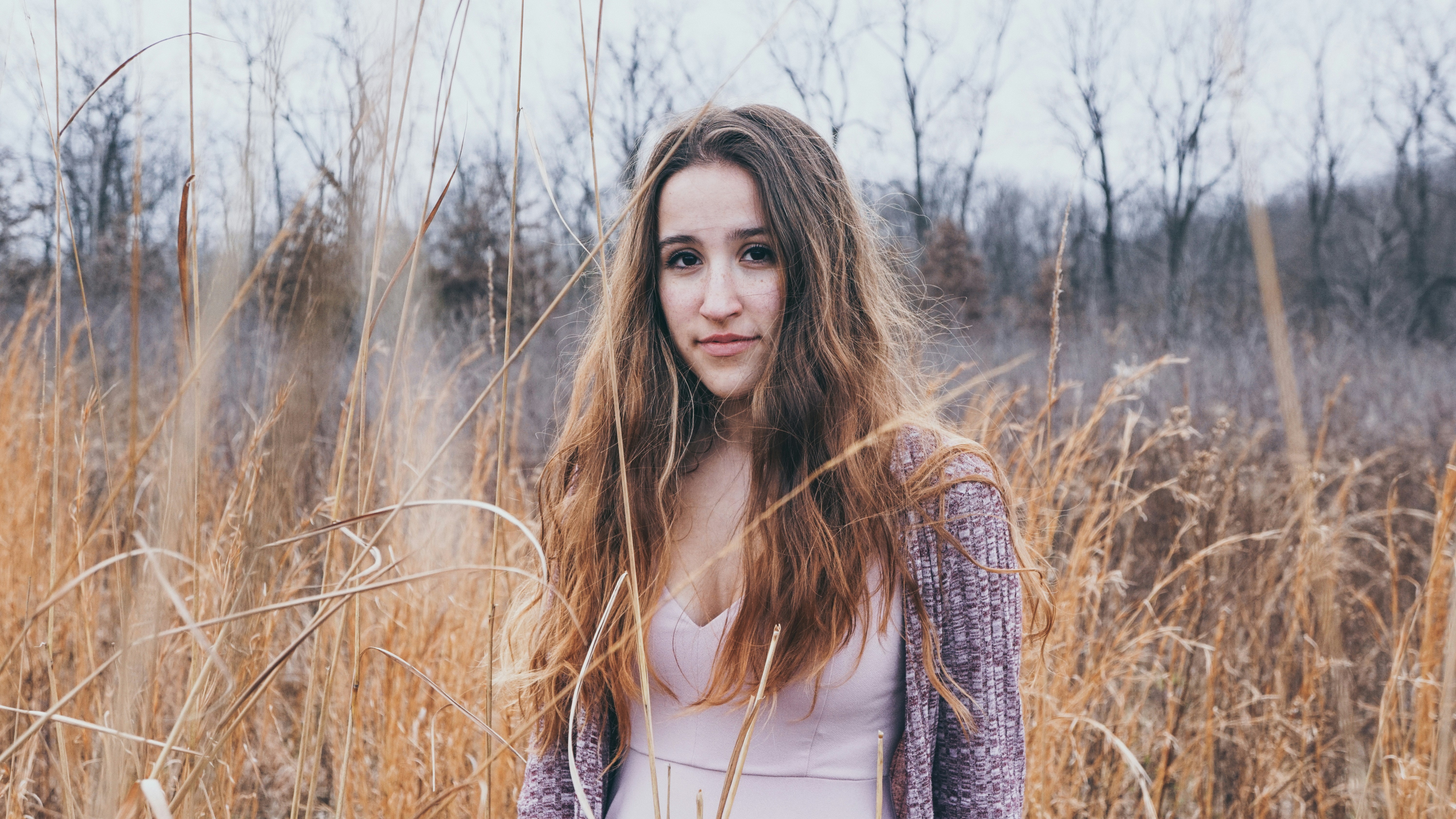 woman wearing gray cardigan beside brown plants