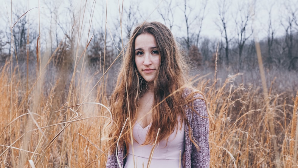 woman wearing gray cardigan beside brown plants