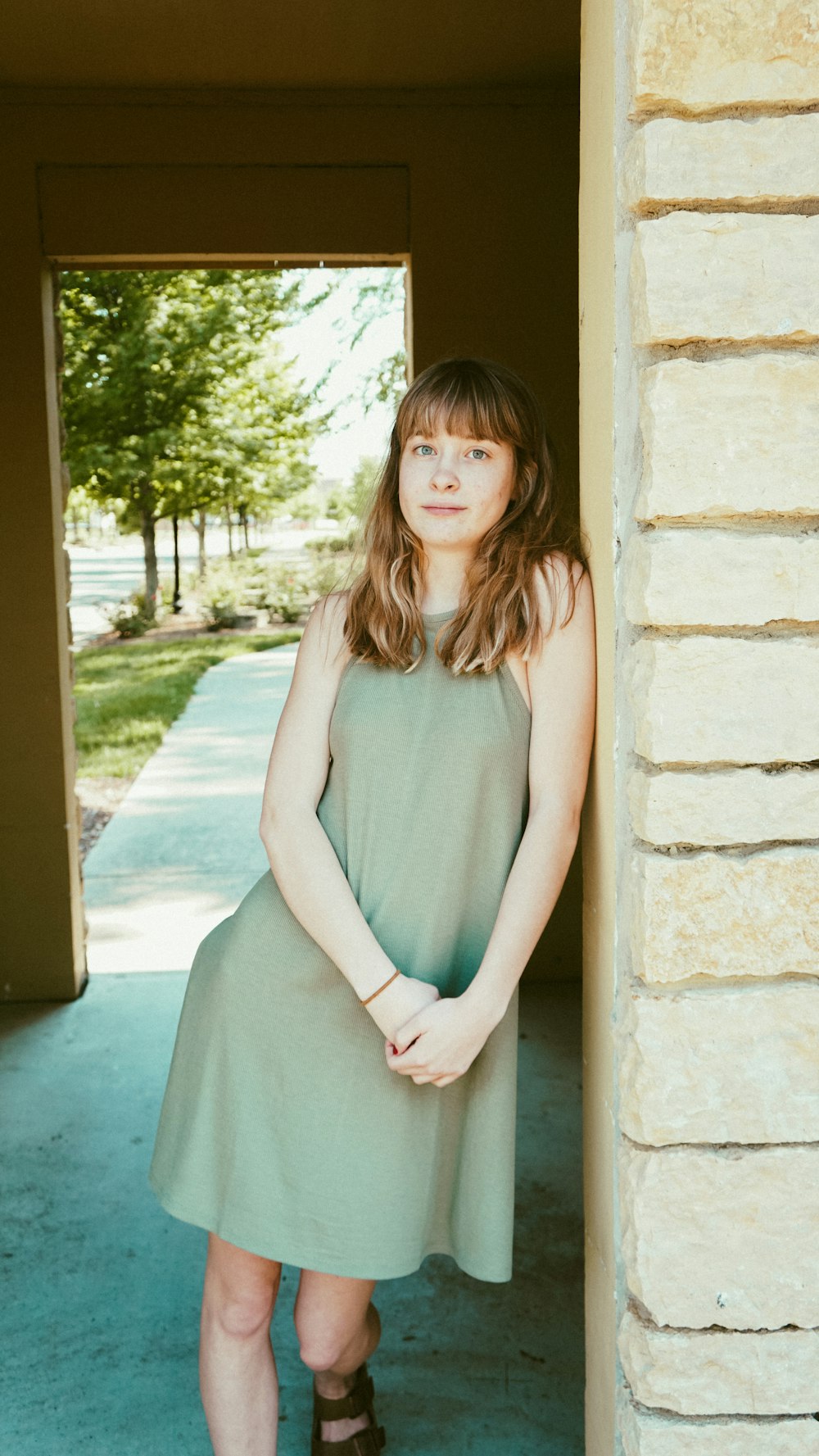 woman standing beside wall at daytime