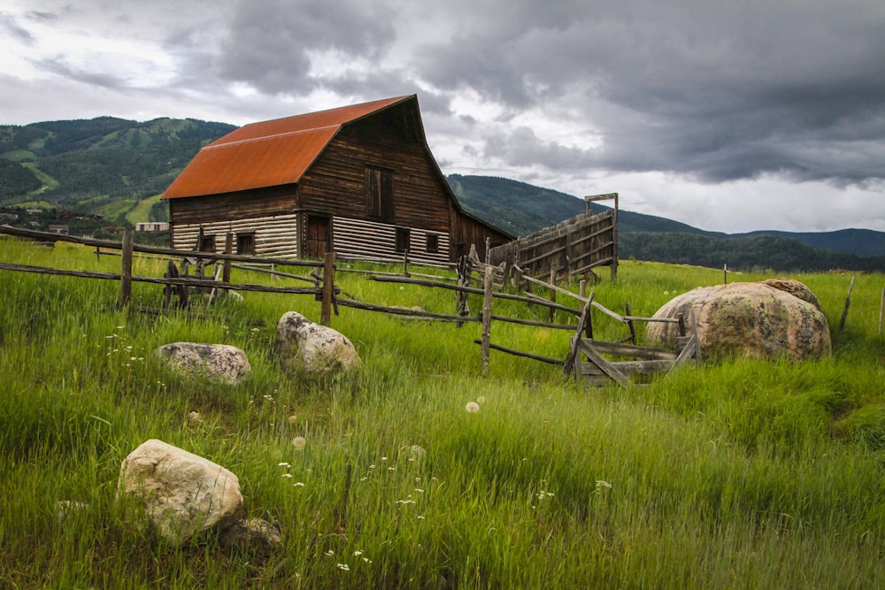 brown wooden barn in high ground at daytime