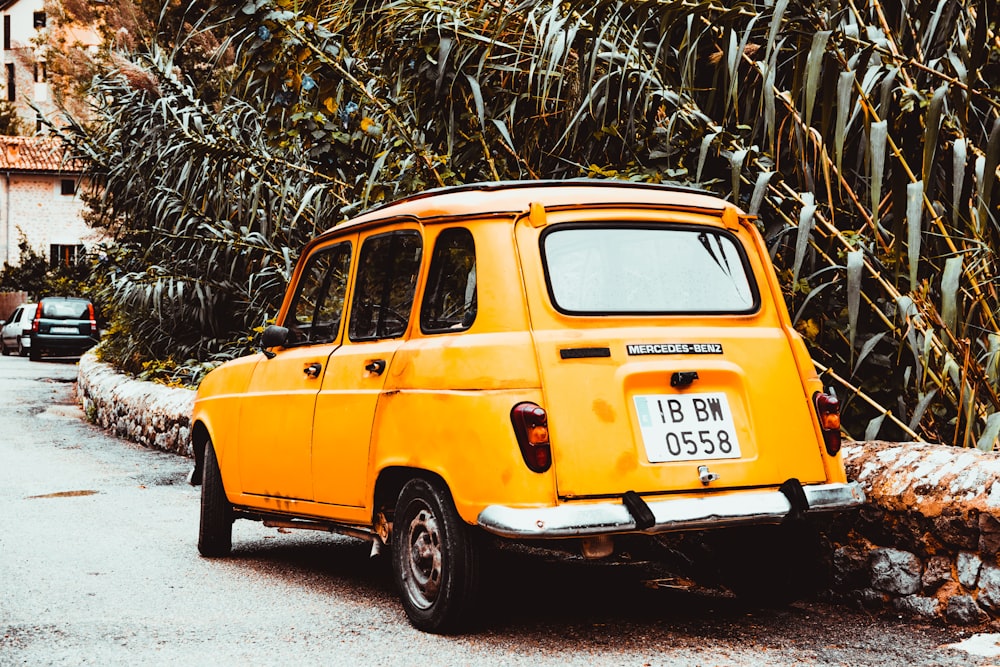 yellow car parked beside green tree