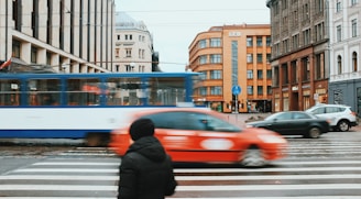 person walking towards pedestrian lane surrounded by high-rise building during daytime