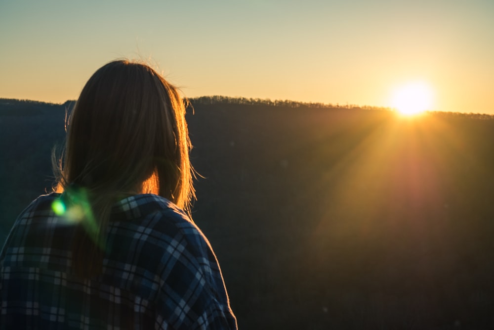 silhouette of woman in front of mountain at golden hour