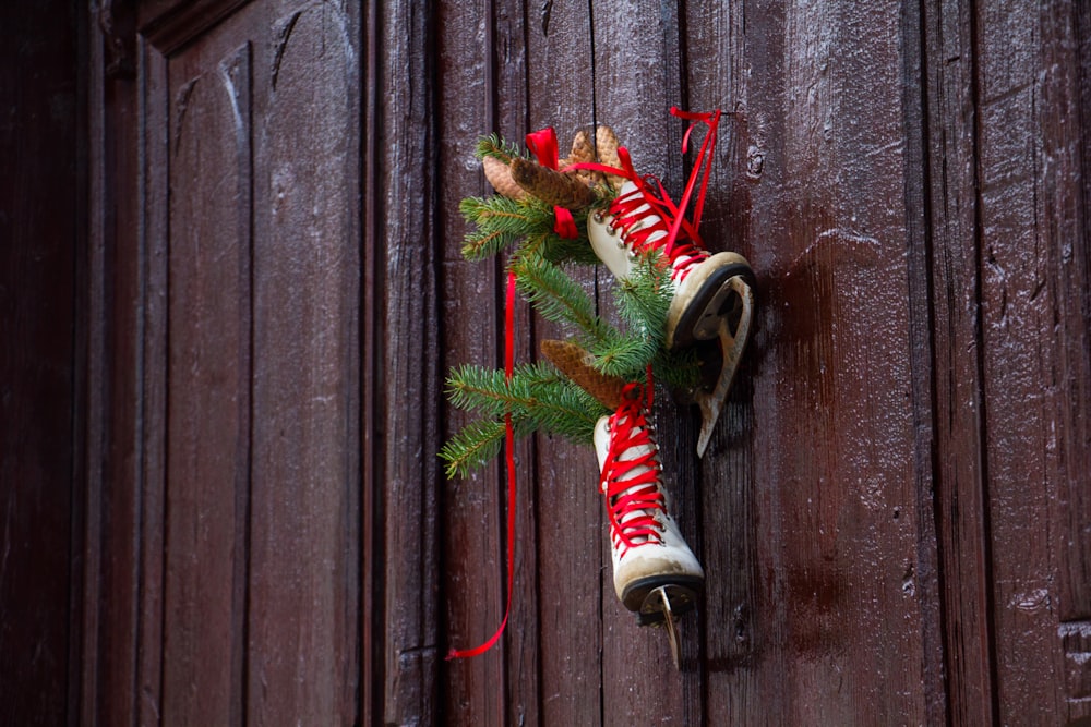 pair of white ice skates hanging on brown wall