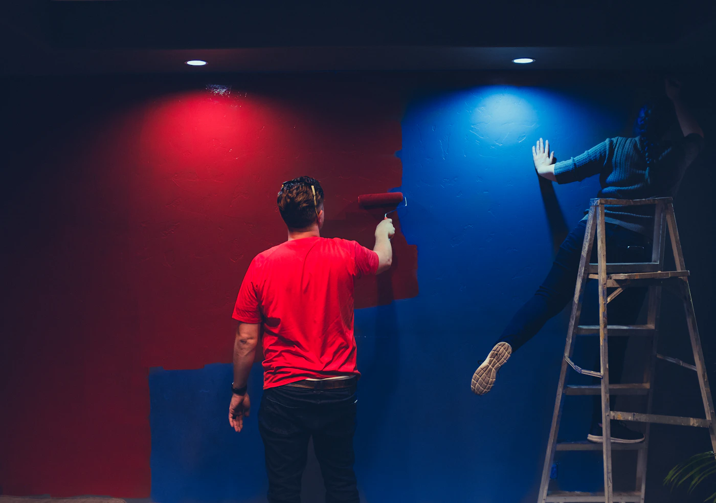 Twee mensen schilderen samen een grote wand