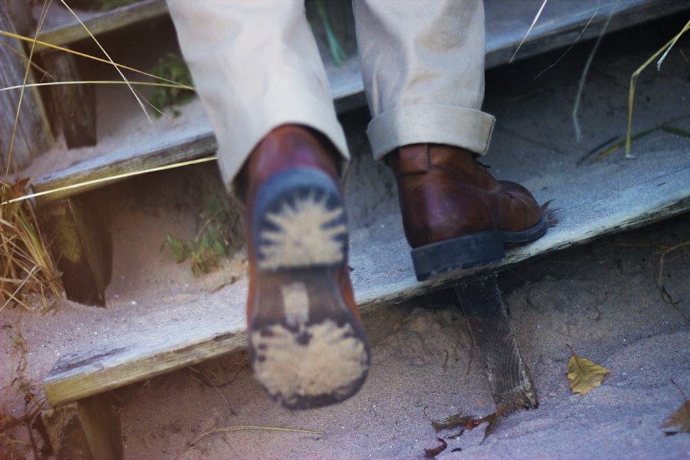 person walking on black steel stairs with white sand