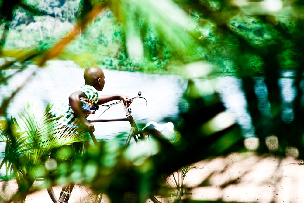 a man riding a bike down a street next to a river