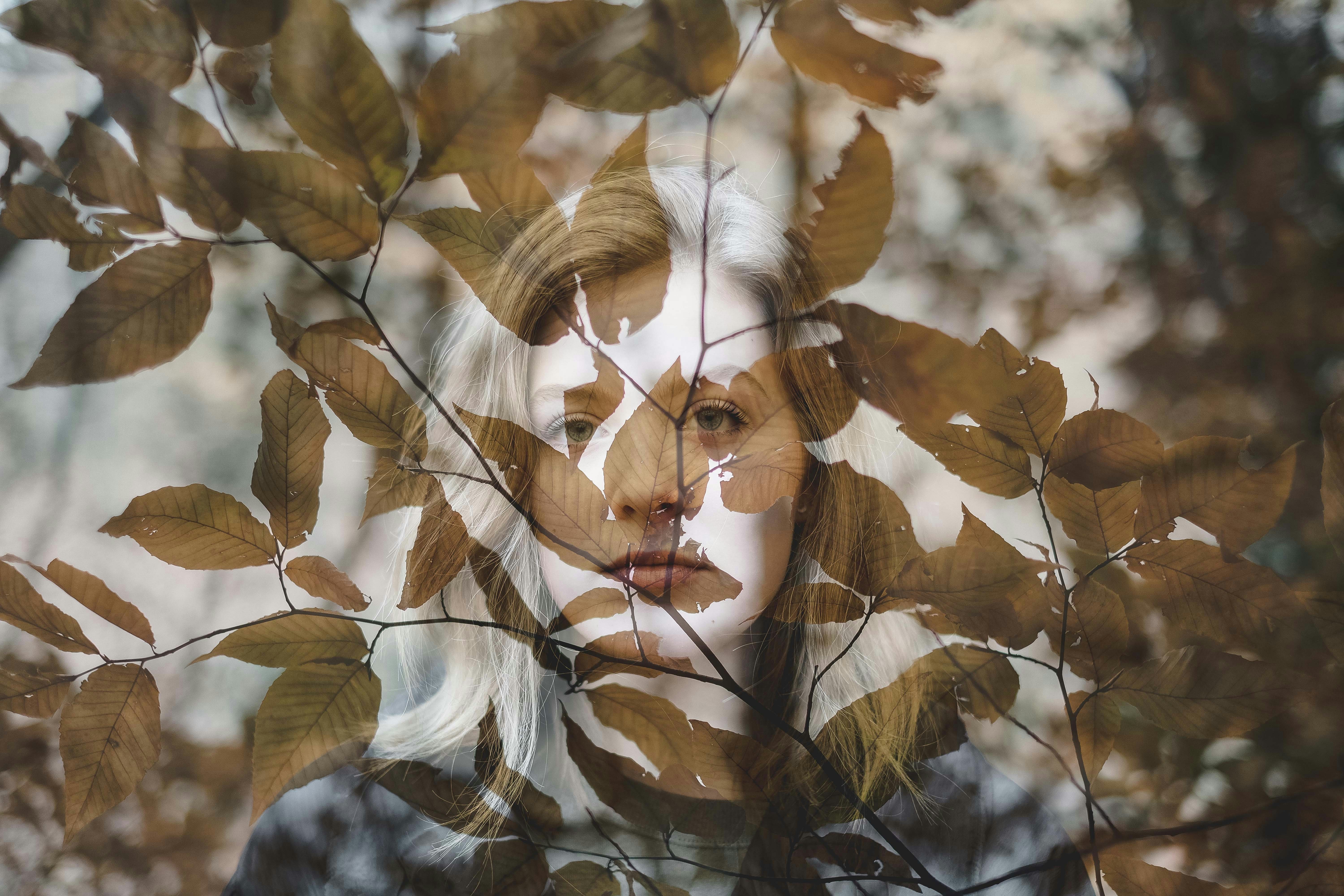 woman behind brown leaves